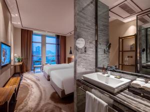 a bathroom with a bed and a sink and a shower at 半山酒店 in Kaili
