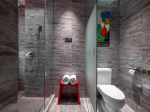 a bathroom with a toilet and a glass shower at 半山酒店 in Kaili