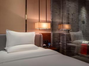 a bedroom with a white bed and two lamps at 半山酒店 in Kaili