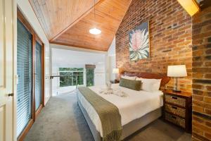 a bedroom with a bed and a brick wall at Hunchy Hideaway in Montville