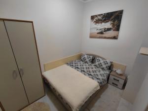 a small bedroom with a bed and a picture on the wall at Bonaca in Igalo