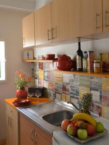 a kitchen with a sink and a plate of fruit at Downtown dell Arte in Novi Sad