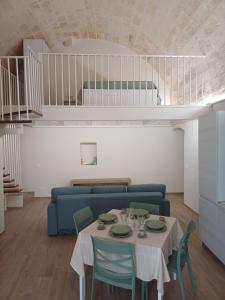 a living room with a table and a blue couch at Il Nido nel Borgo in Ginosa