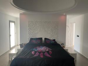ein Schlafzimmer mit einem Bett mit schwarzer Bettdecke in der Unterkunft DarDif in Wadrān