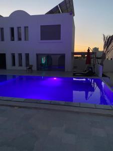 ein blauer Swimmingpool vor einem Haus in der Unterkunft DarDif in Wadrān