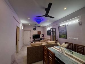 a living room with a couch and a ceiling fan at Zenith apartement in Trivandrum