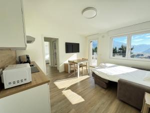 a bedroom with a bed and a kitchen with a desk at BedE-Bike Apartments in Casazza