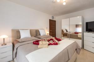 ein Schlafzimmer mit einem großen Bett und einem Fernseher in der Unterkunft House Zrile with garden and jacuzzi in Baška + 33 Fotos