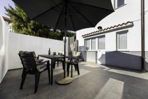 a patio with a table and chairs and an umbrella at Apartment Jelusic in Baška