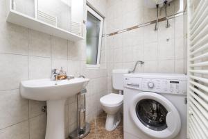 a bathroom with a sink and a washing machine at Apartment Jelusic in Baška