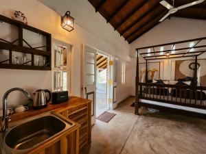 a kitchen with a sink and a baby crib at Cozy Nook Cottage in Tangalle