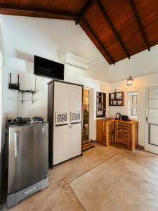 a kitchen with a stainless steel refrigerator and a counter at Cozy Nook Cottage in Tangalle +7 photos