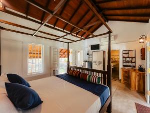 a bedroom with a large bed with blue pillows at Cozy Nook Cottage in Tangalle