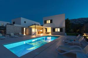 a villa with a swimming pool at night at Villa Aurora in Baška