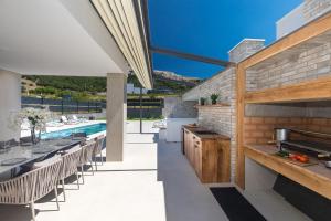 a patio with a table and chairs and a swimming pool at Villa Aurora in Baška