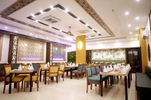 a restaurant with tables and chairs and a ceiling at HOTEL RAH INN - Yog Nagari Rishikesh Railway Station in Rishīkesh