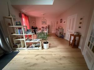 a room with a wooden floor with a potted plant in it at Le Relais des Capucines in Largnac