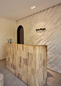 a lobby with a stone wall with a counter at Lyvin Bingin Villas in Uluwatu