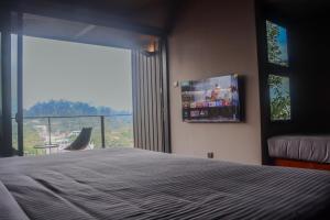 a bedroom with a bed and a large window at Elevate Ella Resort & Spa in Ella