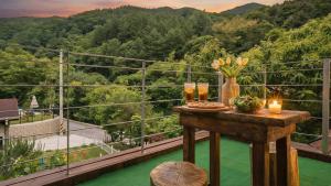 a table on a balcony with a view of a mountain at Gapyeong Areuno Pet Pension in Gapyeong +2 photos