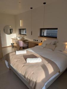 a bedroom with a large bed with two pillows at Les Hôtes des Maillets in Les Maillys