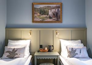 two beds in a room with a picture on the wall at Hotel Breiseth in Lillehammer +67 photos