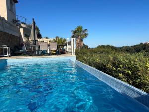 a swimming pool with blue water in front of a house at Chambre avec piscine, jacuzzi, vue mer et montagne, plage à pied in Roquebrune-sur-Argens