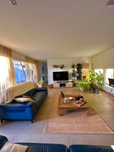 a living room with a blue couch and a coffee table at A MUREDDA in Bonifacio