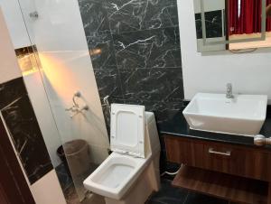 a bathroom with a white toilet and a sink at VR Homes in Chennai
