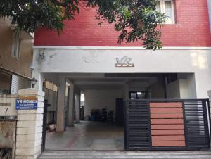 a garage entrance to a building with a red brick wall at VR Homes in Chennai