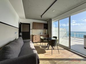 a living room with a couch and a table and a kitchen at South 32 Hotel by Zzzing in Birżebbuġa