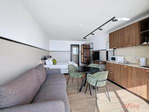 a living room with a couch and a table and a kitchen at South 32 Hotel by Zzzing in Birżebbuġa