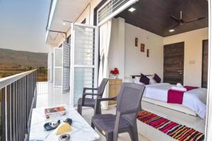 a bedroom with a bed and a balcony at ll EMPYREAN STAY ll LUXE ll FORTUNE VILLA ll 4BHK ll AC ll BIG POOL in Lonavala