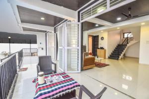 a living room with a table and chairs and a staircase at ll EMPYREAN STAY ll LUXE ll FORTUNE VILLA ll 4BHK ll AC ll BIG POOL in Lonavala