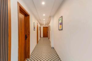 a corridor of a hallway with a door and a tile floor at Treebo Adithi Comforts Inn And Suites in Mysore