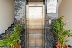 an elevator in a building with potted plants at Treebo Adithi Comforts Inn And Suites in Mysore +31 photos