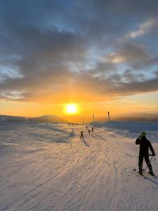 a group of people skiing down a snow covered slope at Hotell Nederhögen Vildmarkscenter in Rätan