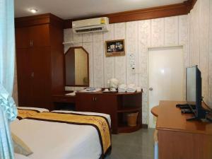 a bedroom with a bed and a desk and a television at Samroiyod Holiday Resort in Sam Roi Yot