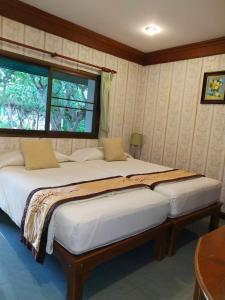 a bedroom with two large beds with a window at Samroiyod Holiday Resort in Sam Roi Yot