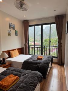 two beds in a room with a large window at Catba Backpackers - Sea Vibe Pool Bar & Bungalow in Cat Ba +106 photos