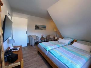 a bedroom with a bed and a table and a chair at Gästehaus Schuppe in Tarp in Tarp