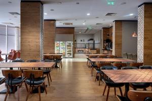 a restaurant with wooden tables and chairs at Best Western PLUS Premium Inn in Sunny Beach