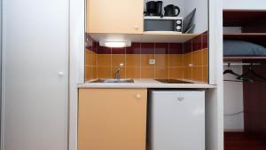 a small kitchen with a sink and a microwave at Le St Clair N208 ST2 in Agde