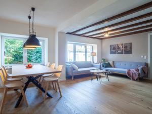 a living room with a table and a blue couch at Fuchsbau nähe Sorpesee, ebenerdig mit Kamin und Garten in Sundern