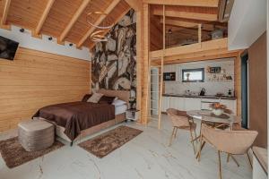 a bedroom with a bed and a table and a kitchen at Bükk Hill Garden in Miskolc