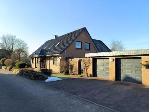 a house with two garage doors and a driveway at Gästehaus Schuppe in Tarp in Tarp
