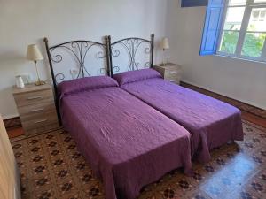 a bed with a purple comforter in a bedroom at Casa Alvarez Tazacorte in Tazacorte