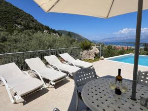a patio with a table and chairs and a pool at Villa Christina Nidri in Nydri