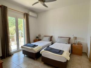 two beds in a room with a window at Villa Christina Nidri in Nydri +20 photos