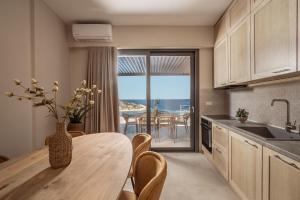 a kitchen with a table and a dining room with a view at Ventalia Villas, 3BR Sea View and Infinity Pool by Villa Mana Gers in Agios Nikolaos